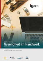 Gesundheit im Handwerk - ein Laptop auf einer Werkbank umgeben von Werkzeugen