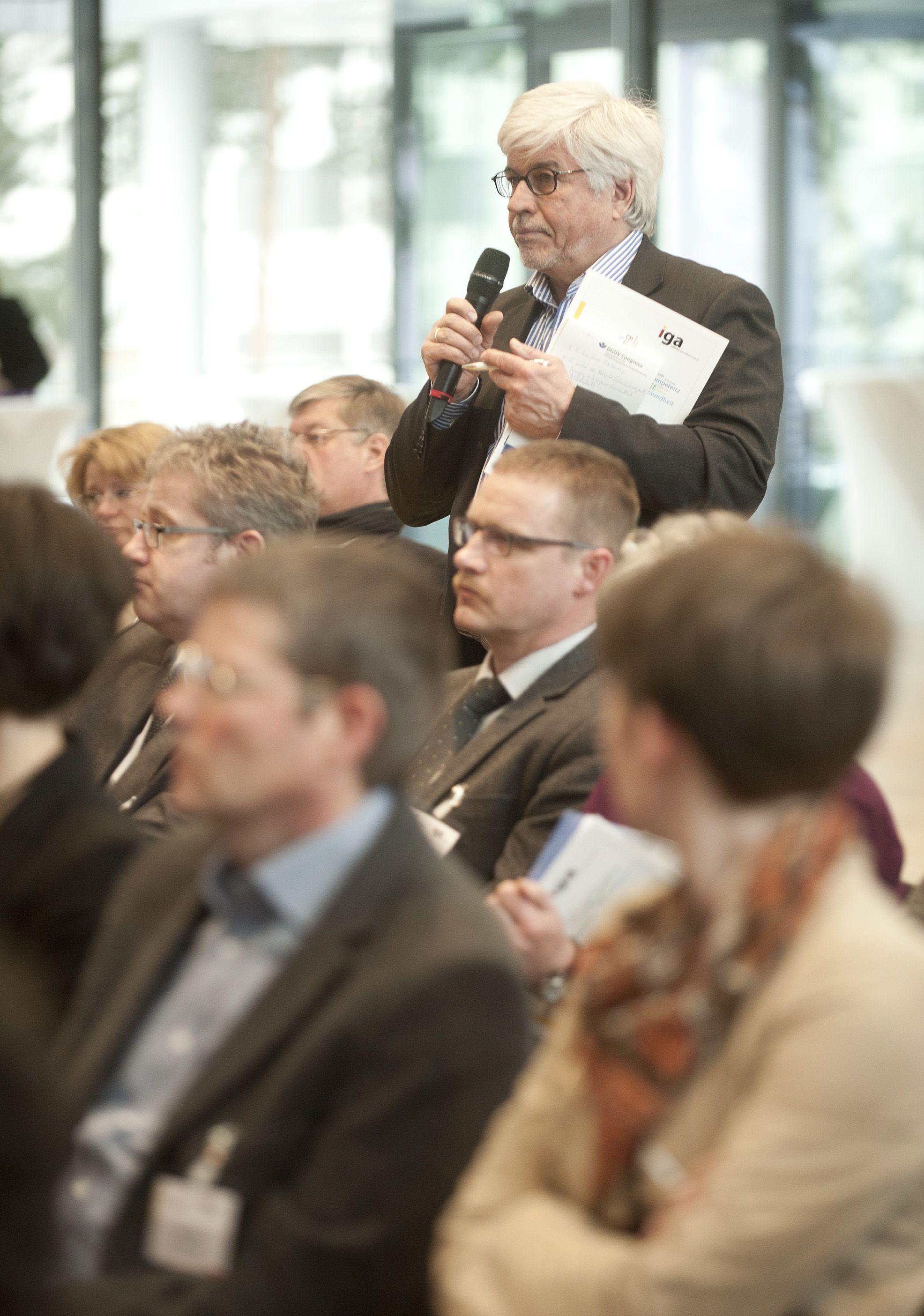 iga.Kolloquium 2013: Teilnehmer mit Mikrofon richtet eine Frage an das Plenum.
